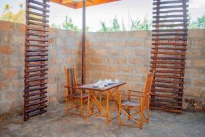 a table and two chairs and a brick wall at Miska Zanzibar in Kizimkazi