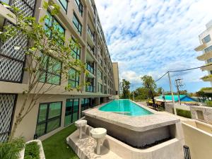 a swimming pool in the courtyard of a building at New Stylish Cozy Condo in Phuket in Ban Thalat Choeng Thale
