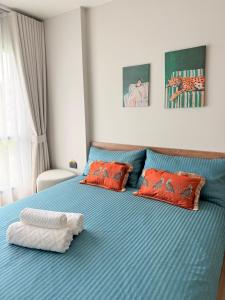 a bedroom with a blue bed with red pillows at New Stylish Cozy Condo in Phuket in Ban Thalat Choeng Thale
