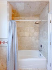 スタンフォードにあるFamily-Friendly 4 Bed 3 Bath Downtown Delightのバスルーム(白いバスタブ、シャワーカーテン付)