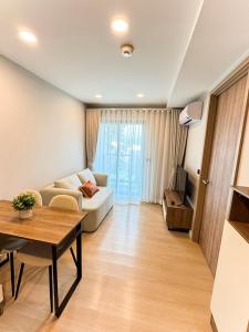 a living room with a couch and a table at New Stylish Cozy Condo in Phuket in Ban Thalat Choeng Thale +24 photos
