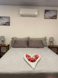 a heart shaped bowl of fruit on a bed at Casa Menta in San Juan del Sur