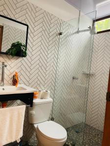 a bathroom with a toilet and a glass shower at Casa Menta in San Juan del Sur