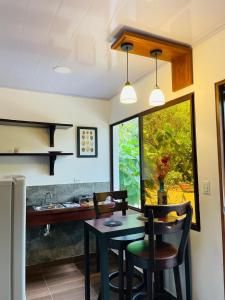 a kitchen with a table and chairs and a window at Casa Menta in San Juan del Sur