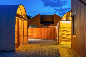 two entrances to a building with a wooden fence at Gangneung Takenomori Glamping Ryokan in Gangneung
