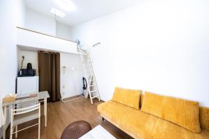 a living room with a couch and a ladder at IL Regalo Tenjin Street Stay in Fukuoka