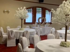 a room with white tables and white chairs and trees at OYO Dunmar House Hotel in Alloa