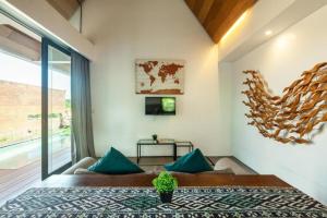 une chambre avec un grand lit avec des oreillers bleus dans l'établissement Luxurious 2BR Villa with Private Pool & Rice Field Views in Ubud, à Ubud