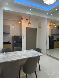 une salle à manger avec une table et des chaises et une cuisine dans l'établissement SUZEN Homestay Sri Indah, à Sandakan