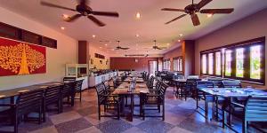 a dining room with tables and chairs and ceiling fans at Gazebo Resort Pattaya in Pattaya Central