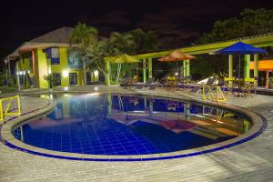 a swimming pool at a resort at night at Ecohotel La Casona Pereira in Pereira