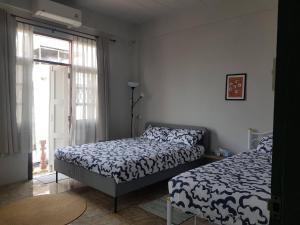 a bedroom with two beds and a window at Dramatic Exit Bangkok - Cozy loft style near Suvarnabhumi Airport in Ban Bang Chan