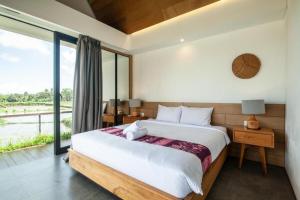 une chambre avec un grand lit et une grande fenêtre dans l'établissement Luxurious 2BR Villa with Private Pool & Rice Field Views in Ubud, à Ubud 37 autres photos