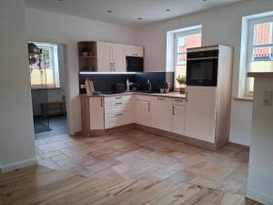 a large kitchen with white cabinets and appliances at Ferienwohnung Ida 90 mq in Gernrode - Harz