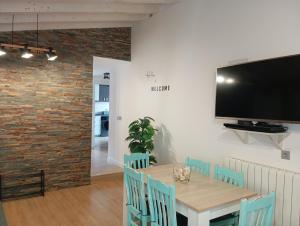 a dining room with a table with chairs and a flat screen tv at La Casita de Suances 2 - a 5 min de la Playa, Ideal Familias y Mascotas in Suances