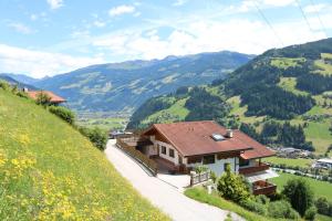 ein Haus auf einem Hügel mit Bergen im Hintergrund in der Unterkunft DieAussicht - Refugium am Berg in Hippach