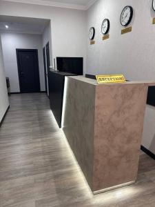 an office with clocks on the wall and a reception counter at Mehran Hostel in Andizhan