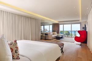 a hotel room with a bed and a red chair at Double - Six, Luxury Hotel - Seminyak in Seminyak +37 photos