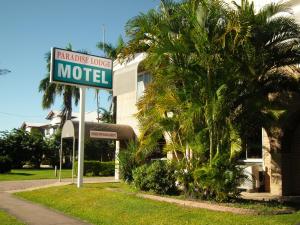 a motel sign in front of a palm tree at Paradise Motel in Mackay