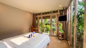 a bedroom with a bed and a sliding glass door at Villa Alisha Pererenan Canggu in Canggu