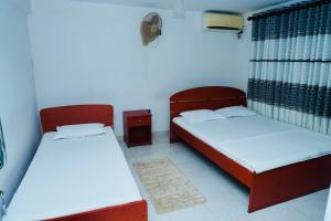 two beds are in a room withthritisthritisthritisthritisthritisthritisthritisthritisthritis at Tamarind Tree House in Wellawaya