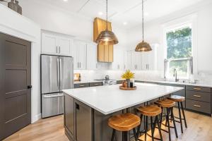 a kitchen with white cabinets and a large island with stools at Heritage Heights-Close to Downtown & Pioneer Park in Walla Walla +23 photos
