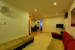 a living room with a couch and a fan at Sara Hotels and Apartments in Nedumbassery