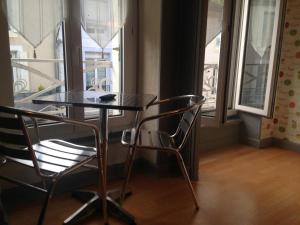 a table and two chairs in a room with a window at Studios des Thermes in Bourbonne-les-Bains
