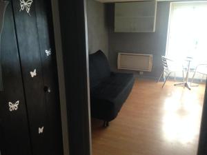 a living room with a couch and a chair at Studios des Thermes in Bourbonne-les-Bains