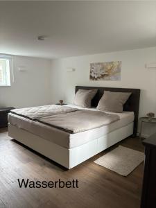 a bed in a bedroom with a white wall at Waldblick am Rhein - Natur & Citynah - in Bonn