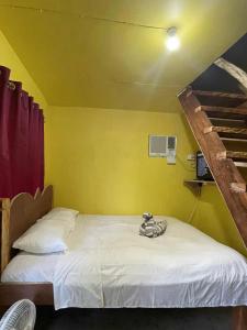a room with a bed with a yellow wall at Destiny Rainbow Beach Resort in Siquijor +82 photos