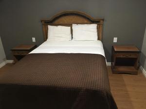 a bed in a room with two nightstands and a bed sidx sidx sidx at Town House Motel in Lynwood