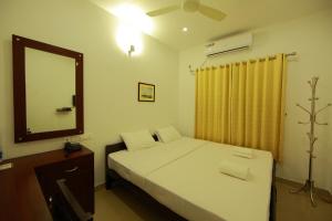 a small bedroom with a bed and a mirror at Sara Hotels and Apartments in Nedumbassery +29 photos