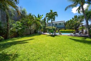 Un patio con sillas de jardín y una piscina. en Kisana Residence - Pleasant apartment with pool, close to beach, en Pointe aux Cannoniers