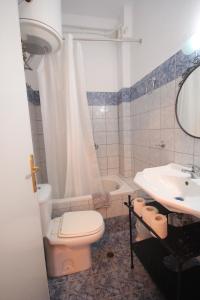 a bathroom with a toilet and a sink and a tub at Eden Apartments in Neo Klima +13 photos