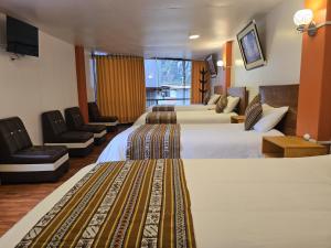 a hotel room with two beds and a tv at Amakonkay Machupicchu in Machu Picchu