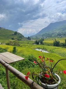 a vase with flowers on a rail with a view of a valley at SaPa Farmer House in Sapa