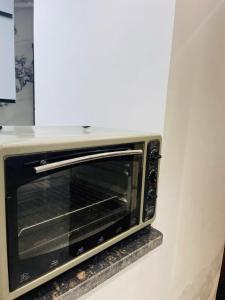 Un horno microondas colocado en una repisa en una cocina. en بورتو سعيد شاليهات لإيجار من المالك, en Puerto Saíd