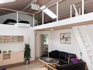 a loft apartment with a black couch and a table at 12 person holiday home in Egå-By Traum in Åstrup +21 photos