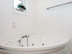 a white bath tub in a white bathroom at 12 person holiday home in Egå-By Traum in Åstrup