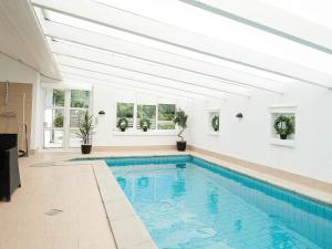 a swimming pool in a house with a white ceiling at 12 person holiday home in Egå-By Traum in Åstrup