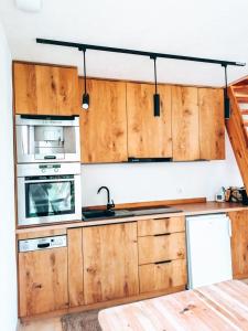 a kitchen with wooden cabinets and a sink and a microwave at Biodomek in Choszczno