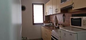 a kitchen with a sink and a microwave at Peja Urban Stay in Peje