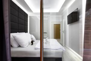 グダニスクにあるApartament Nadmorski Goldのベッドルーム(白いベッド、黒いヘッドボード付)