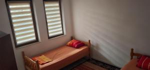 a bench in a room with two windows at Peja Urban Stay in Peje +3 photos