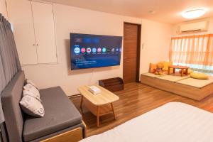 a living room with a couch and a tv at Skytree Tokyo Residence Aoto in Tokyo