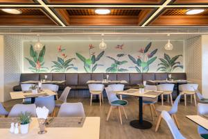 a restaurant with tables and chairs and a mural at Springfield Village Golf & Spa in Cha Am +81 photos