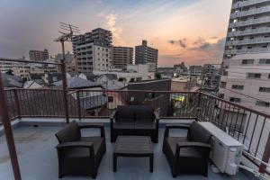 a balcony with chairs and a view of a city at Skytree Tokyo Residence Aoto in Tokyo