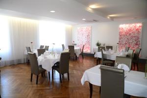 a dining room with white tables and chairs at La Maison Blanche in Romanèche-Thorins