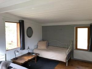 una camera con un letto e un tavolo e due finestre di Small house, charming cabin, Cozy place a Montbrun-Bocage